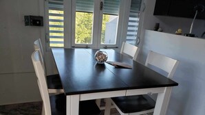 A dining table with white chairs, a glass vase with stones, and a rubber duck on the table. - Wake Up to Ocean Views: Your Puerto Rico Paradise Awaits! (Yabucoa)