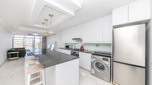 A modern kitchen with a central island, built-in appliances, and pendant lighting.