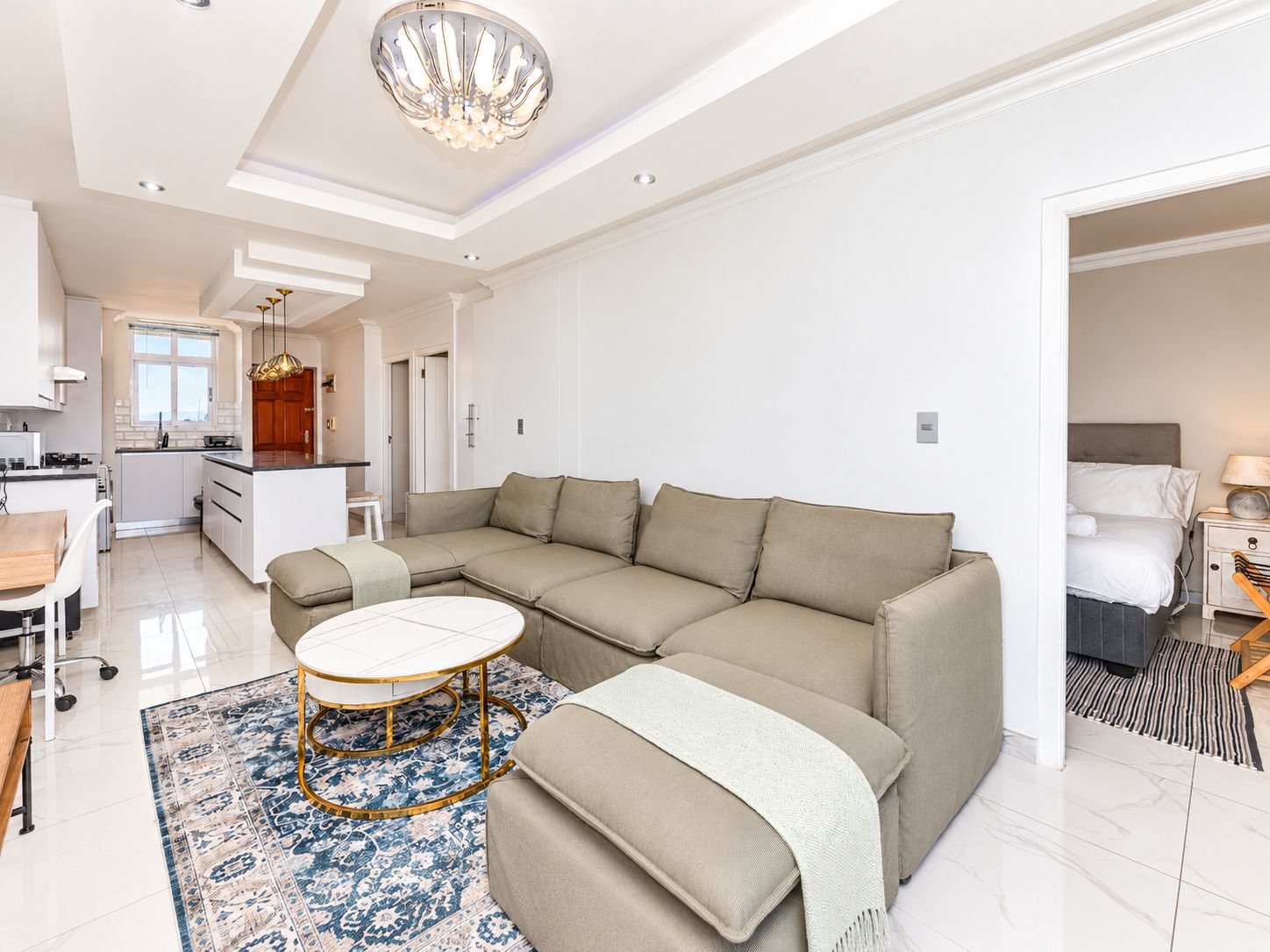 A modern living room with a sectional sofa, a round coffee table, and a patterned rug.