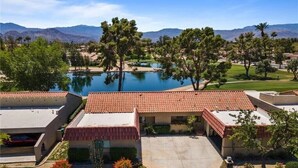 A resort with a swimming pool, a tennis court, and a mountain backdrop. - Peaceful Waterfront Getaway (pet-friendly) (Palm Desert)