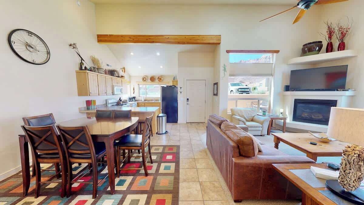 Un grand espace de vie comprenant une table à manger, des chaises, un canapé et un téléviseur.