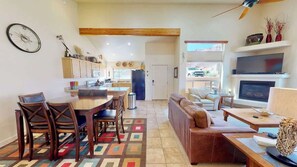 A spacious living area with a dining table, chairs, a sofa, and a TV.