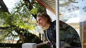 A person leaning on a glass door with a view of trees and a wooden deck outside. - Cabaña El Encino II en Real del Monte (Mineral del Monte)