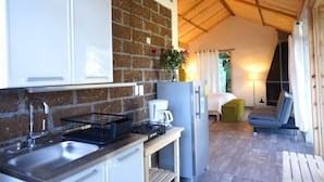 A compact kitchen with a brick wall, a sink, a coffee maker, and a refrigerator. - Cabaña El Encino II en Real del Monte (Mineral del Monte)