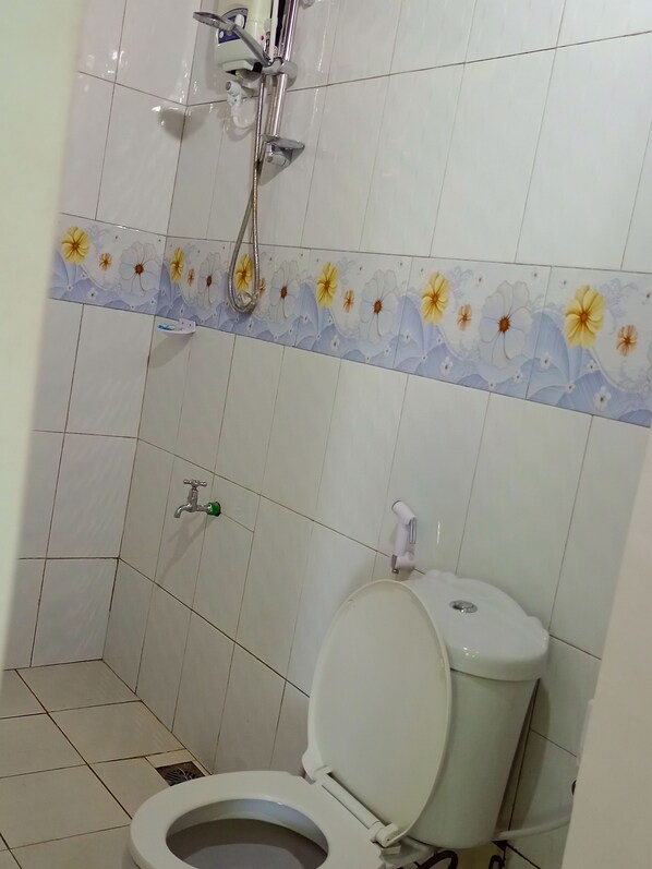A bathroom with a toilet, a shower, and a toilet paper holder. - MJ one bedroom Luxury Tents by the creek (Mtwapa)