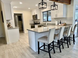 Keittoastiat/astiat/ruokailuvälineet, ruokailupöytä, keittiösaareke