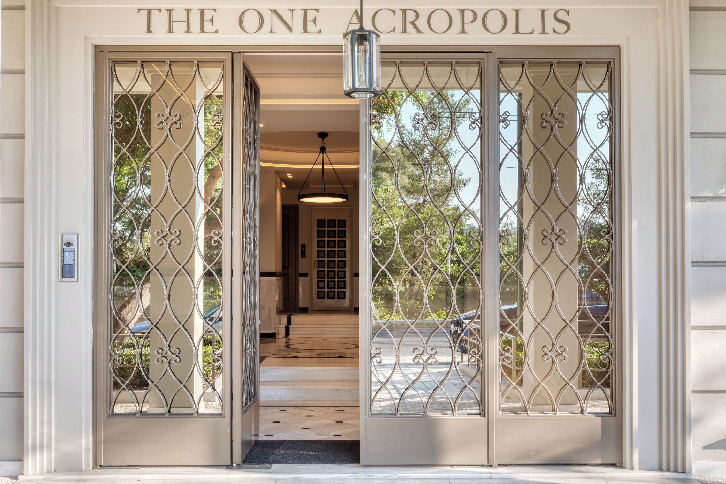 La entrada de The One Acropolis, con una reja metálica y un cartel sobre la puerta.