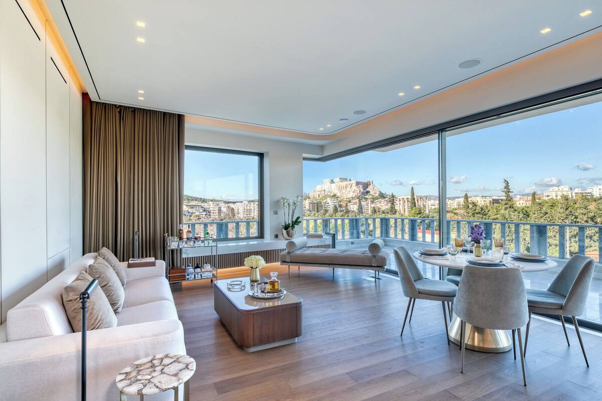 A modern living room with a sofa, coffee table, and dining area.