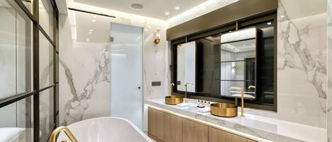 A modern bathroom with a freestanding bathtub, a large mirror, and marble walls.
