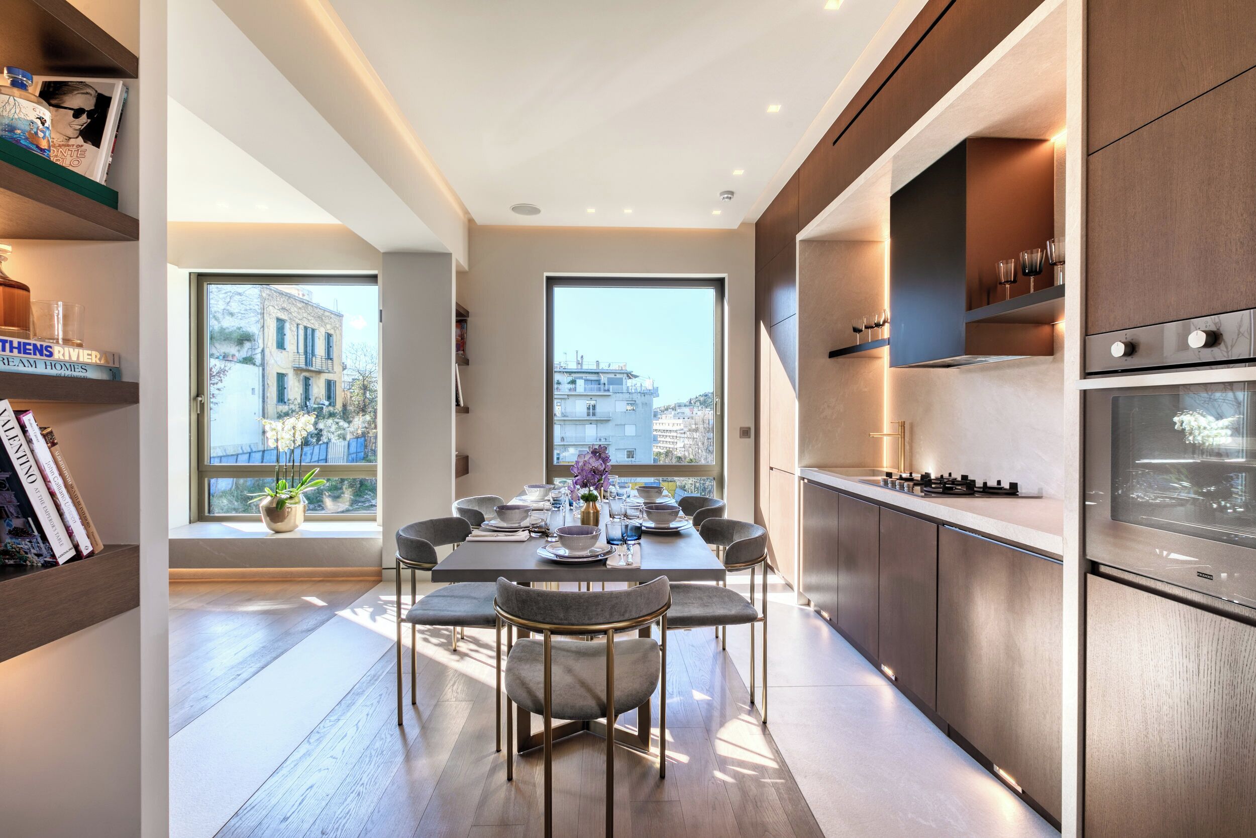 Una cocina moderna con comedor, ventanas amplias y vistas a edificios.