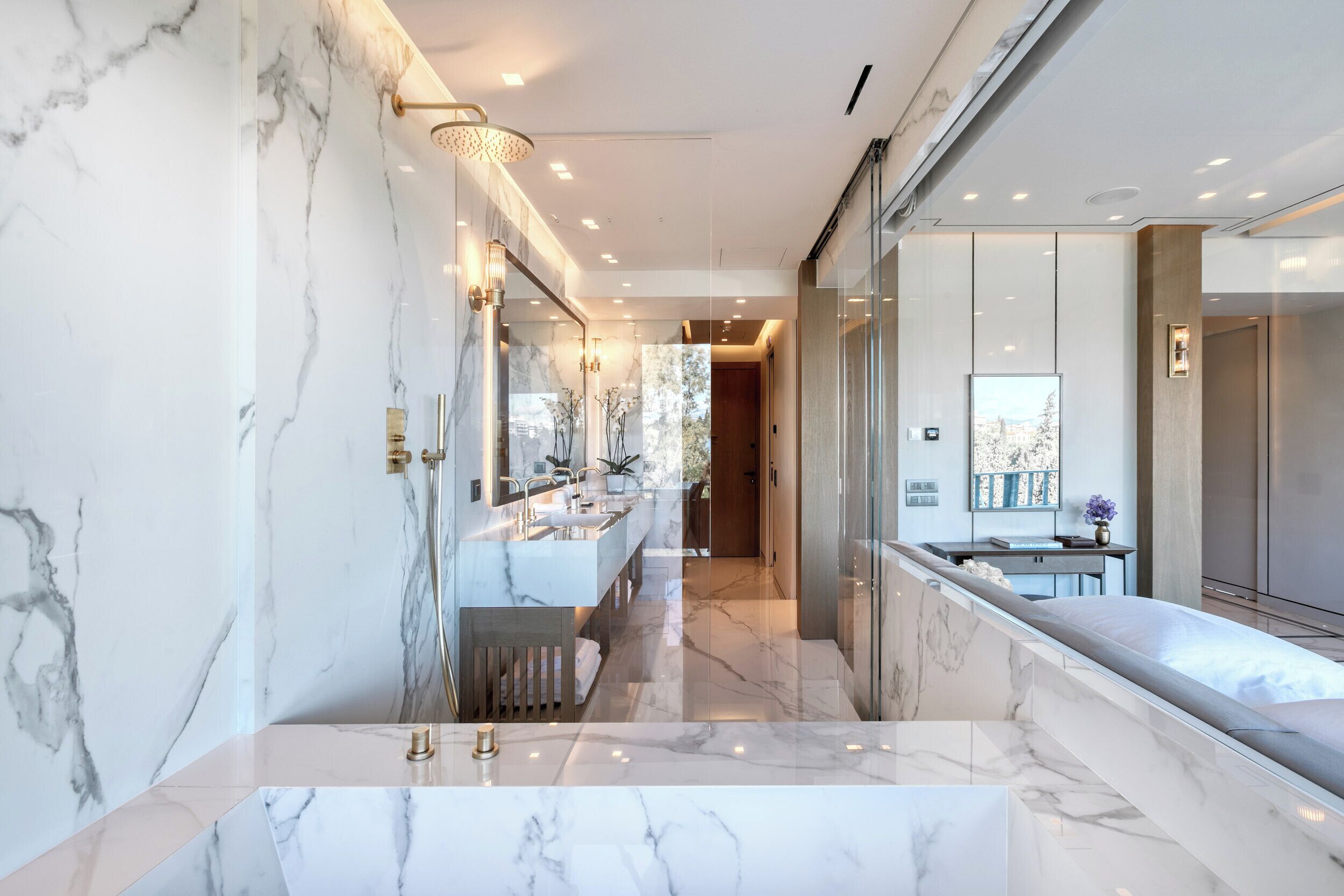 A modern bathroom with marble walls and a large vanity.