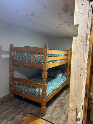 Un lit superposé avec une structure en bois et une literie à motifs.