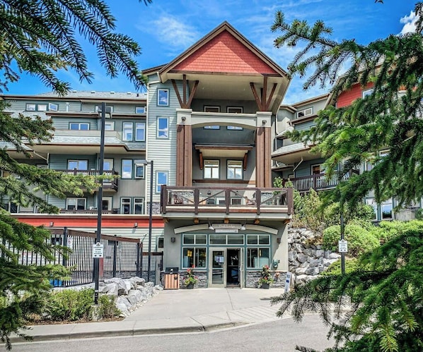 Un hotel de varios pisos con una entrada destacada, balcones y fachada de piedra.