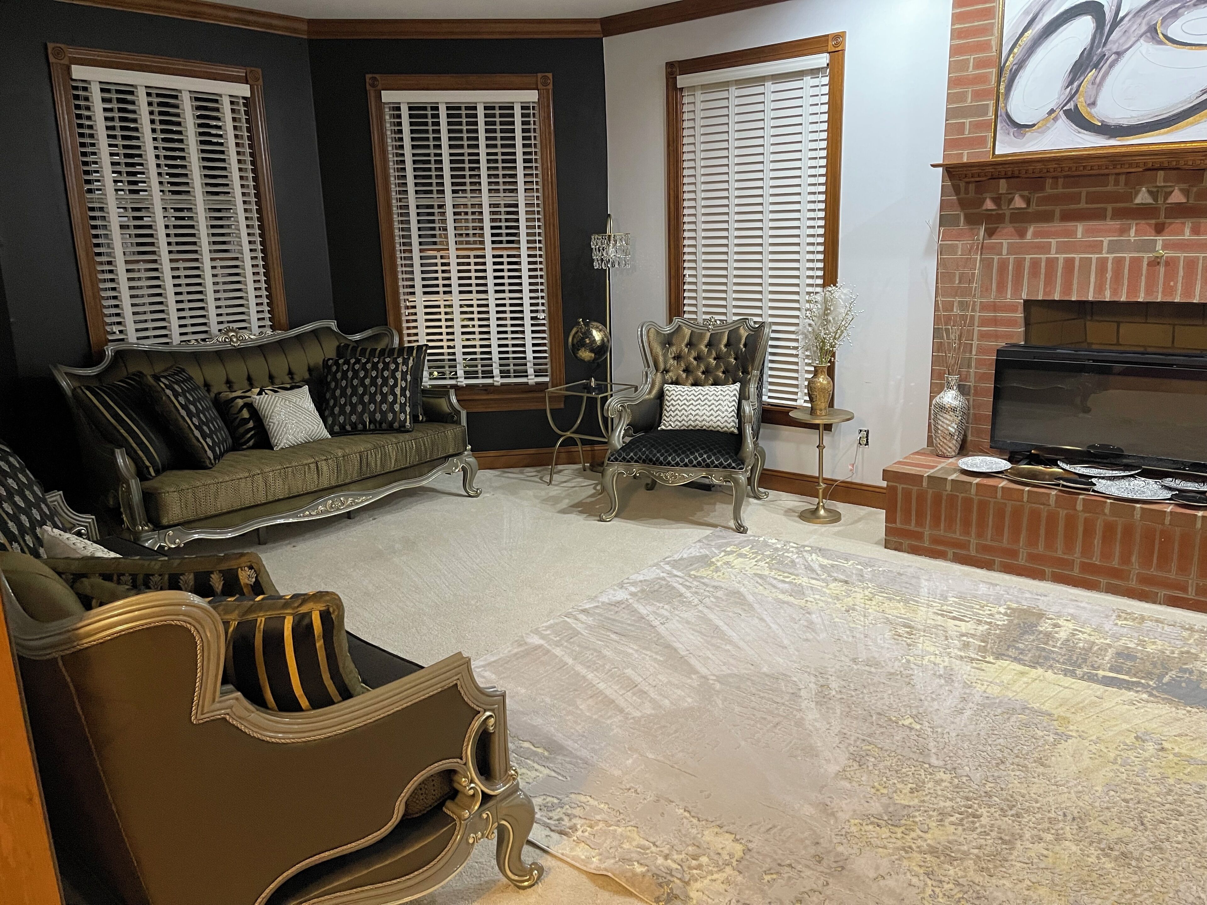 A living room with a sofa, armchair, and fireplace.