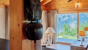 Un interior de madera con decoración rústica, que incluye un techo de madera y un ventanal con vistas a la montaña.