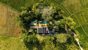 An aerial view of a property with a swimming pool, solar panels, and lush greenery. - Villa Alba (Ahangama)