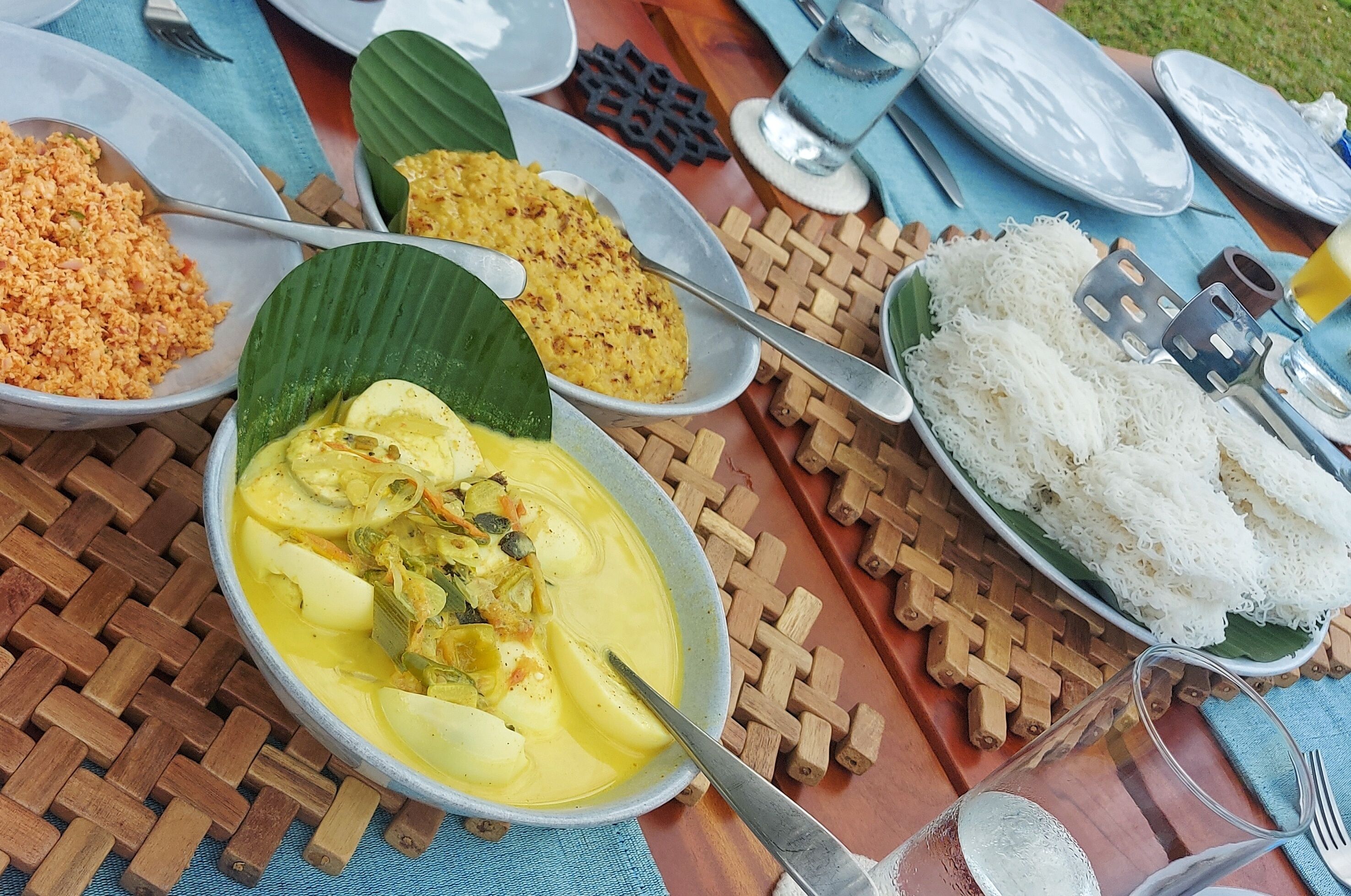 A table with various dishes including rice, curry, and a bowl of soup.