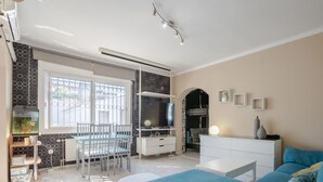 Un salon moderne comprenant un coin repas, un téléviseur et un canapé confortable.