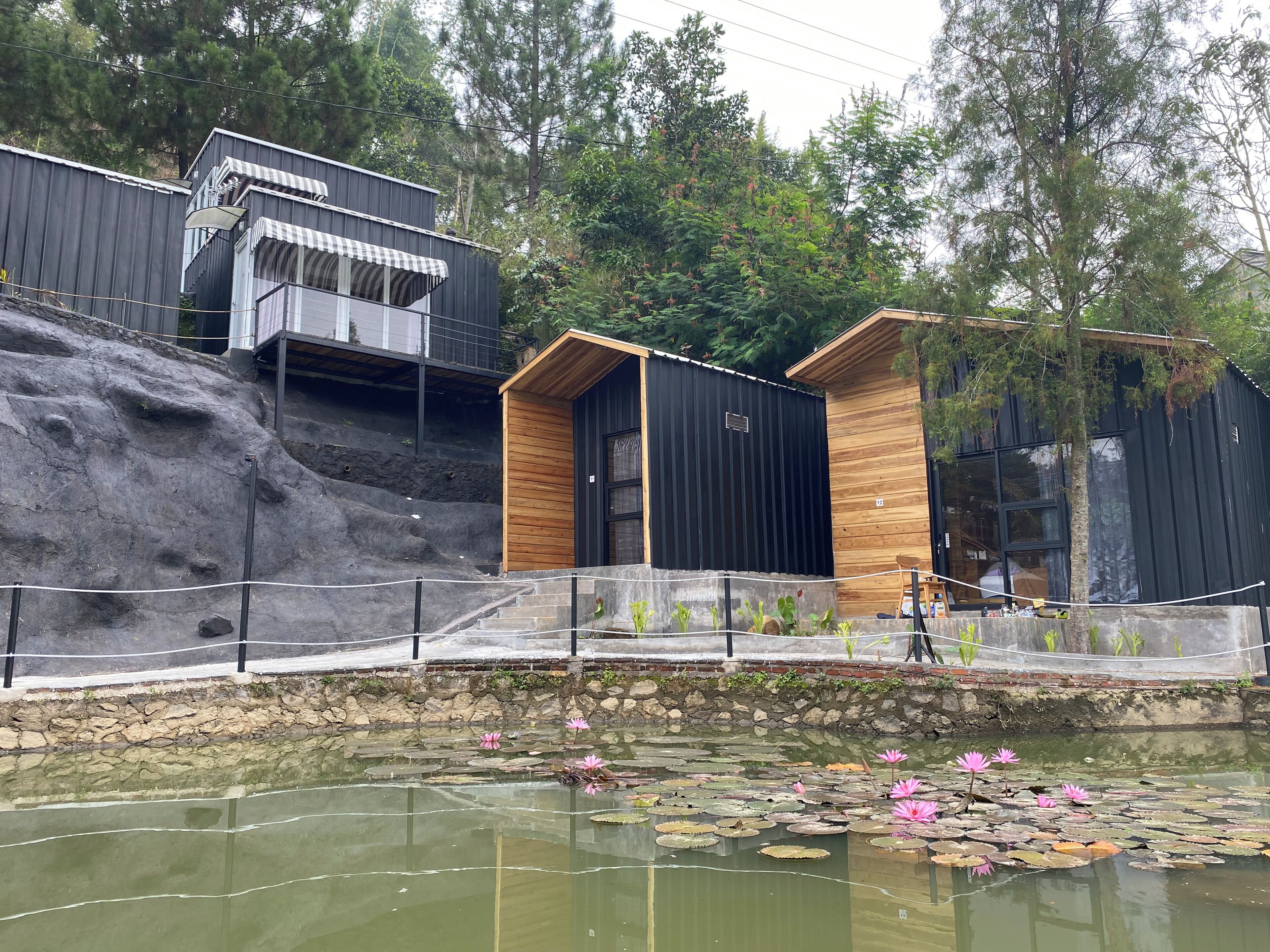 A modern building with a wooden facade and a stone retaining wall.