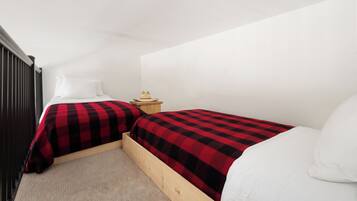 Un dormitorio con dos camas, una mesita de noche y un cabecero de madera.