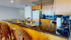 A modern kitchen with a central island, stainless steel appliances, and wooden cabinetry.