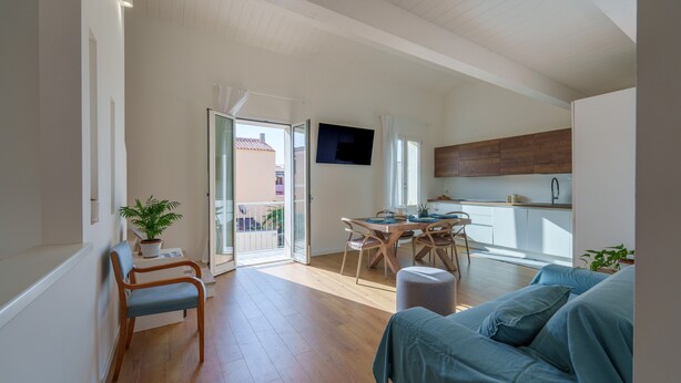 Eine moderne Wohnung mit Essbereich, einer Küche, einem Balkon und einem Wohnzimmer.