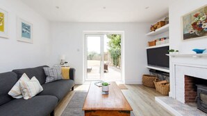 Un salon moderne avec un canapé, une table basse, une cheminée et un téléviseur.