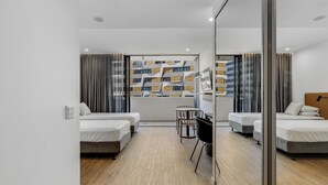 Una habitación de hotel moderna con dos camas, una mesita y una silla.
