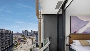 Habitación de hotel moderna con un amplio ventanal que ofrece vistas a la ciudad y a la calle.