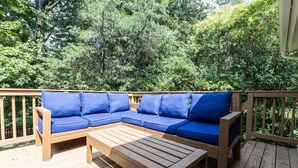 A wooden deck with a blue sectional sofa and a wooden table. - Cozy Single-Story near Pineville Hospital, games (Charlotte)