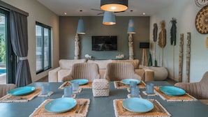Comedor con una mesa dispuesta para cuatro, con platos azules y individuales tejidos.