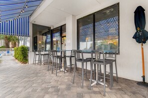 An outdoor seating area with tables and chairs, a covered patio, and a view of the street. - Oceanview, Pools, Hot tub, Indoor pool, 2 Beds (Myrtle Beach)