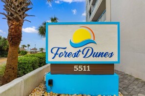 A sign for 'Forest Dunes' with a beach and palm tree in the background. - Oceanview, Pools, Hot tub, Indoor pool, 2 Beds (Myrtle Beach)