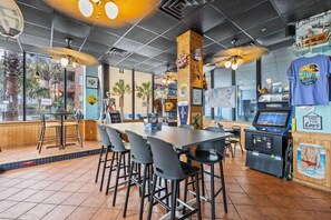 A restaurant interior with a long communal table, individual seating, a jukebox, and a menu board. - Oceanview, Pools, Hot tub, Indoor pool, 2 Beds (Myrtle Beach)