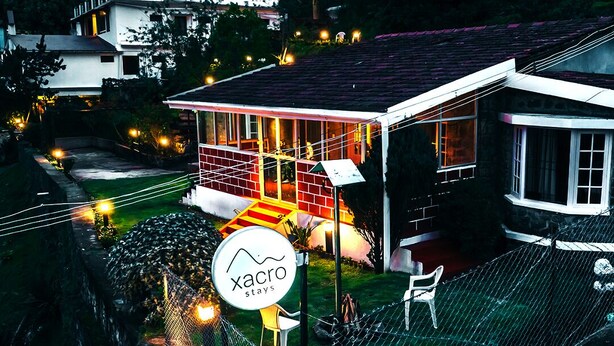 Una casa con patio cercado y un letrero que dice 'Xacro Stays'.