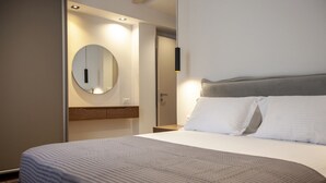 A hotel room with a large bed, a round mirror, and a bedside table. - Villa Olia in Agios Petros (Lefkada)