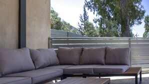 A modern outdoor seating area with a built-in bench and a cushioned bench. - Villa Olia in Agios Petros (Lefkada)