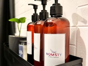 Três frascos de condicionador Homsty numa bandeja preta.