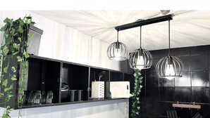 Una cocina moderna con baldosas blanco y negro, utensilios de cocina colgando y luces colgantes.