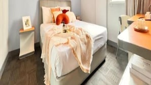 Une chambre à coucher comprenant un lit, une table de chevet et un bureau avec une chaise.