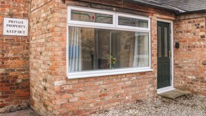A brick building with a large window and a door. There is a sign on the wall that reads "PRIVATE PROPERTY KEEP OUT". - Kilderkin (Bedale)