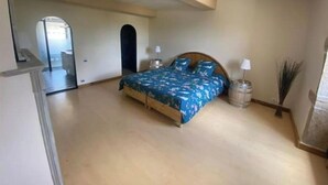 Ein Schlafzimmer mit einem Bett, einem Nachttisch, einer Lampe und einem Spiegel.