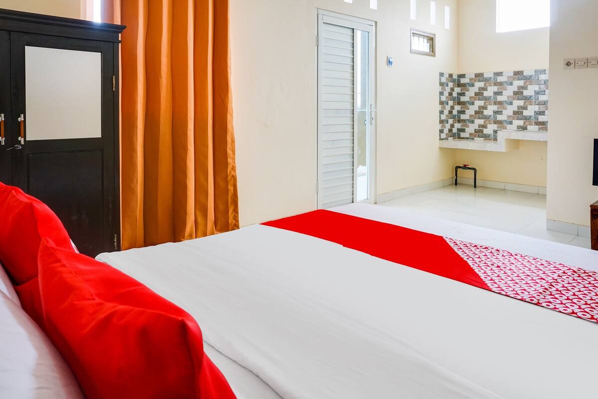 A hotel room with a bed, a wardrobe, a door, and a tiled wall.