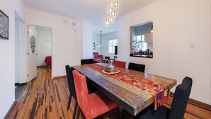A dining area with a wooden table, red and black chairs, a patterned table runner, and hanging pendant lights. - Casa de Chiles - the best spot in Cuauhtémoc (Mexico City)