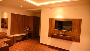 Una sala de estar moderna con piso de madera, un sofá de cuero, un televisor montado en la pared y un mueble de madera.