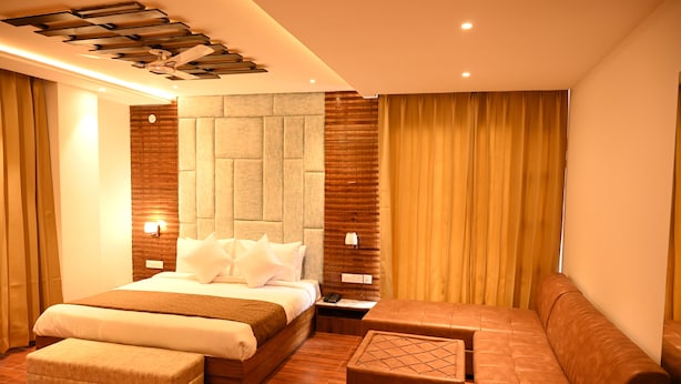 Una habitación de hotel moderna con una cama grande, un sofá y una pequeña mesa.