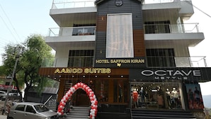 Un hotel con balcones, un letrero que dice 'AAMOD SUITES' y una fachada para 'OCTAVE METTLE'.