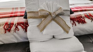 A bedroom with a bed, a window, a pillow with 'RELAX' text, and a towel with a bow.