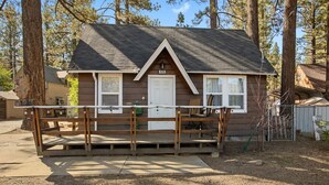 A small cabin with a front porch, a door, and a window.