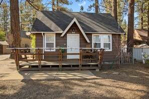A small cabin with a front porch, a door, and a window.